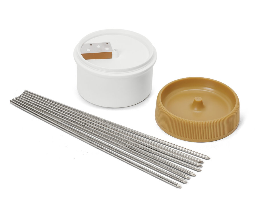 Kerzenherstellungsset mit weißem Behälter, braunem Deckel und Metallkerzendochten.