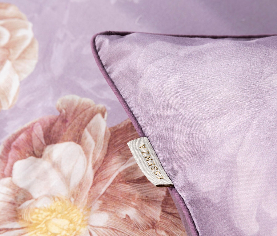 Nahaufnahme eines lila Kissens mit Blumenmuster und einem Etikett mit der Aufschrift ESSENZA.