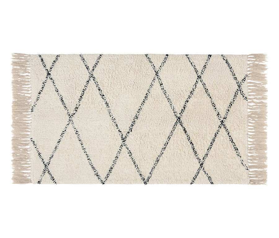 Ein cremefarbener Teppich mit dunklem Rautenmuster und Fransen an den Enden liegt auf einem weißen Hintergrund.