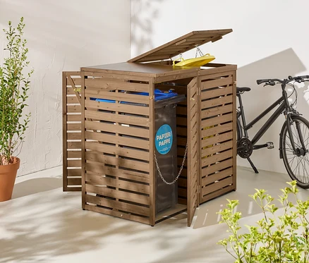 Eine braune Mülltonnenbox aus Holz mit geöffneten Türen und Deckel steht neben einem schwarzen Fahrrad.