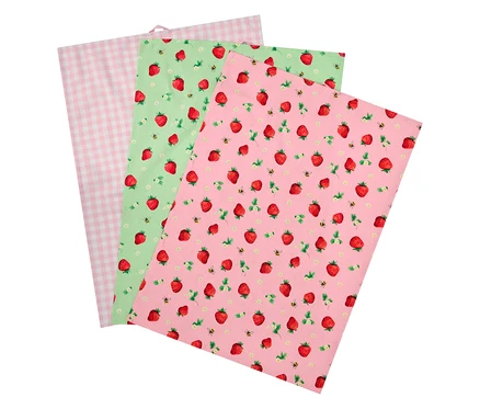 Drei Stoffservietten, eine rosa kariert, eine grüne mit Erdbeeren und Bienen, eine rosa mit Erdbeeren und Bienen.