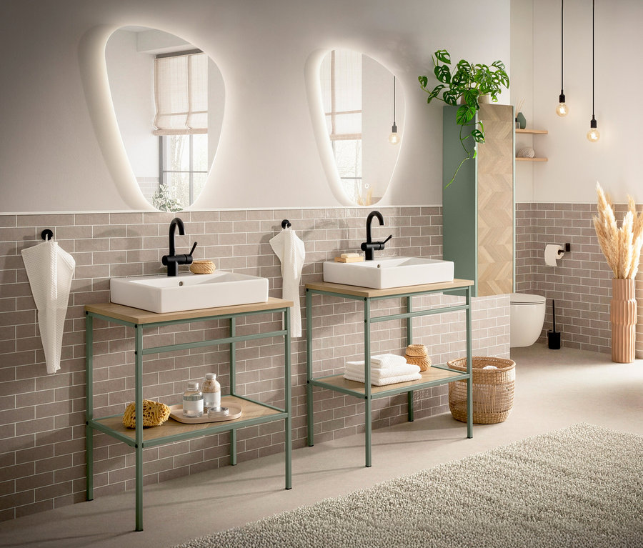 Badezimmer mit zwei Waschtischunterschränken mit hellen Holzplatten und mintgrünen Gestellen unter ungewöhnlich geformten Spiegeln.