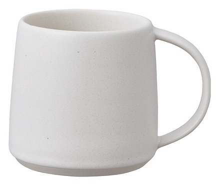Eine einzelne, leere, hellbeige Tasse mit Henkel steht vor einem weißen Hintergrund.