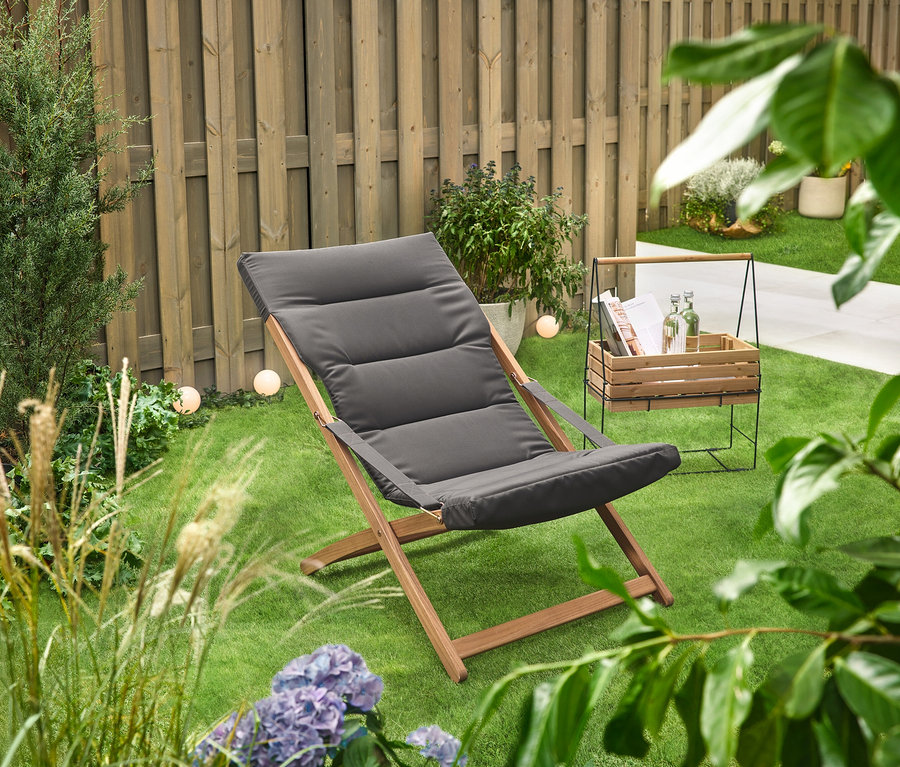 Auf einer grünen Rasenfläche steht ein Kräuterkasten mit Tragegestell »Elin« neben einem Liegestuhl.