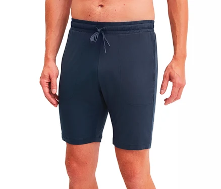 Eine Person trägt dunkelblaue Shorts mit elastischem Kordelzugbund und Vordertaschen, von der Taille bis zu den Knien abgebildet.