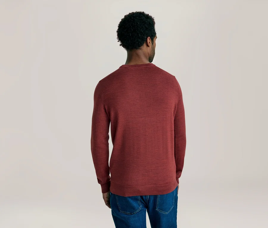 Mann von hinten in einem roten Langarmshirt und blauen Jeans.