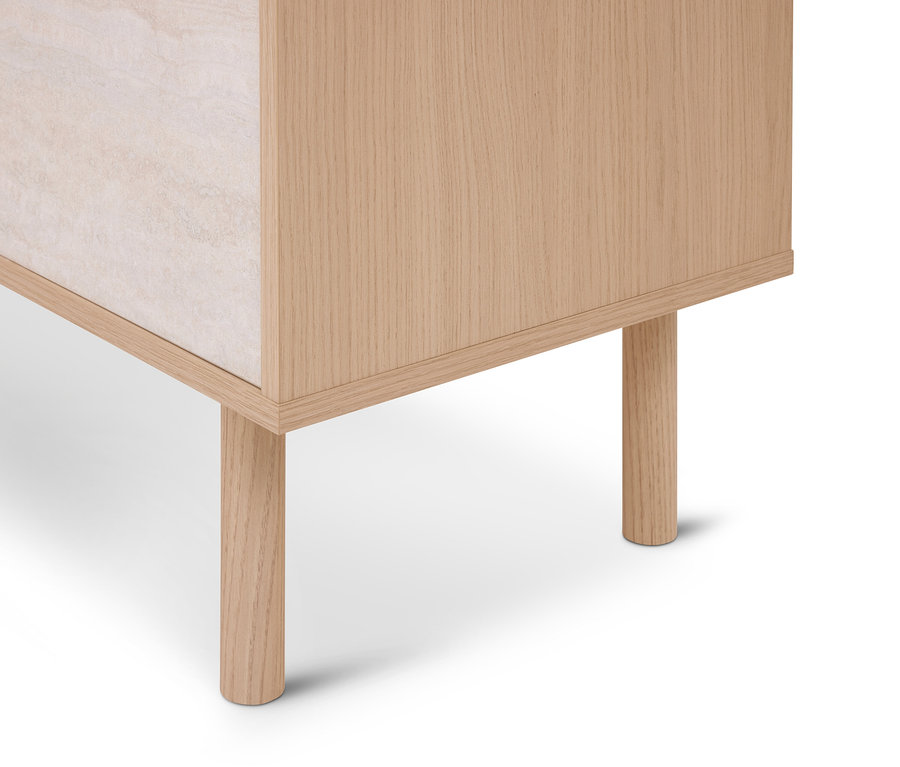 Untere Ecke eines hellen Holzschranks mit runden Holzbeinen und einer hellen, strukturierten Seitenplatte.