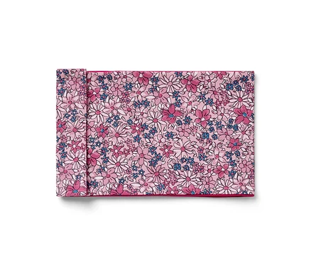 Ein gefaltetes Stoffserviette mit Blumenmuster in Rosa, Weiß und Blau.