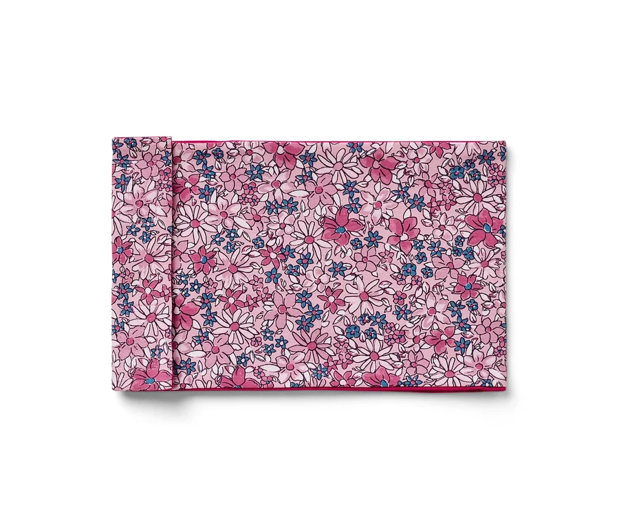 Ein gefaltetes Stoffserviette mit Blumenmuster in Rosa, Weiß und Blau.