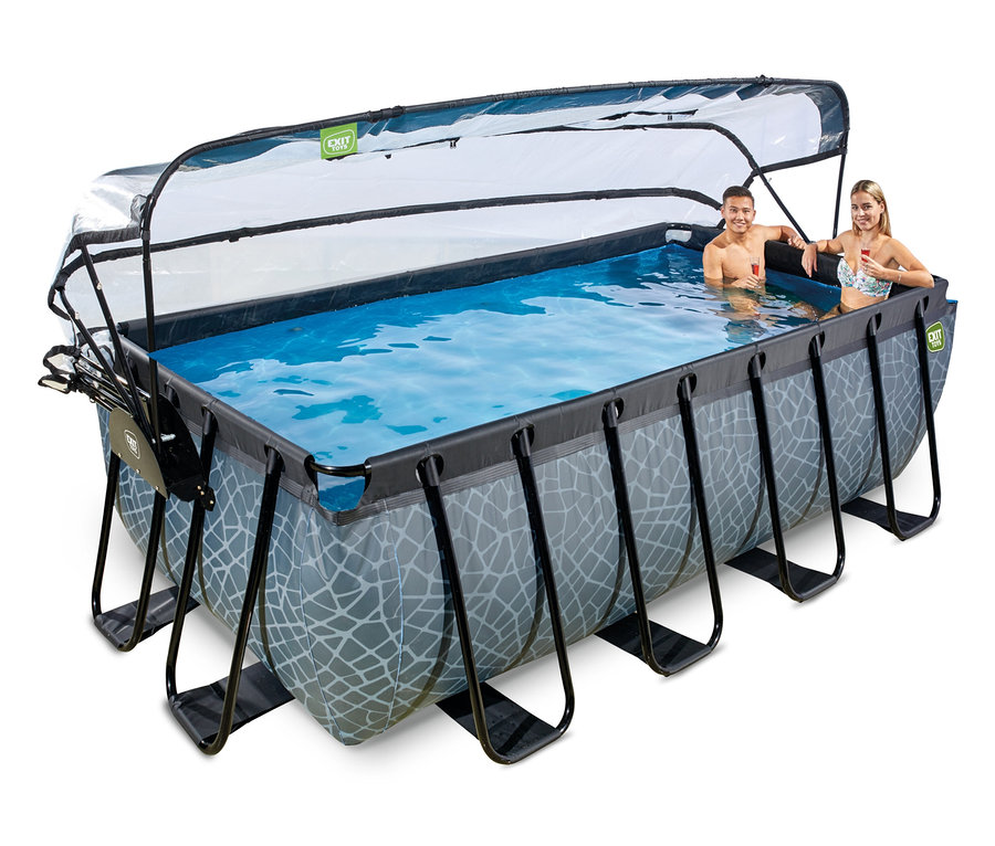 Ein Mann und eine Frau entspannen sich im EXIT Pool-Set, Steinoptik, 400 x 200 cm, mit transparenter Abdeckung. Sie lächeln und halten Getränke im blauen Wasser.