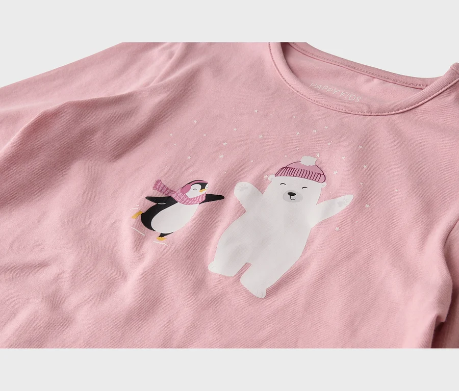 Rosa Langarmshirt mit einem Motiv eines eislaufenden Pinguins mit rosa Schal und eines Eisbären mit rosa Mütze, umgeben von weißen Sternen. Innen ist das Etikett 'HAPPY KIDS' sichtbar.