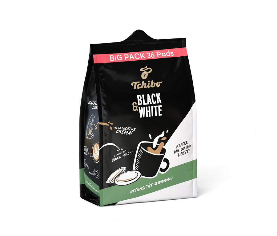 Schwarze, weiße und grüne Verpackung für Tchibo BLACK & WHITE Pads mit 36 Pads. Die Packung zeigt eine Tasse Kaffee mit Crema und den Text "MEGA LECKERE CREMA!".