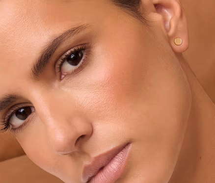 Porträt einer Frau mit braunen Haaren, die 375 Gold Ohrstecker Classic trägt.