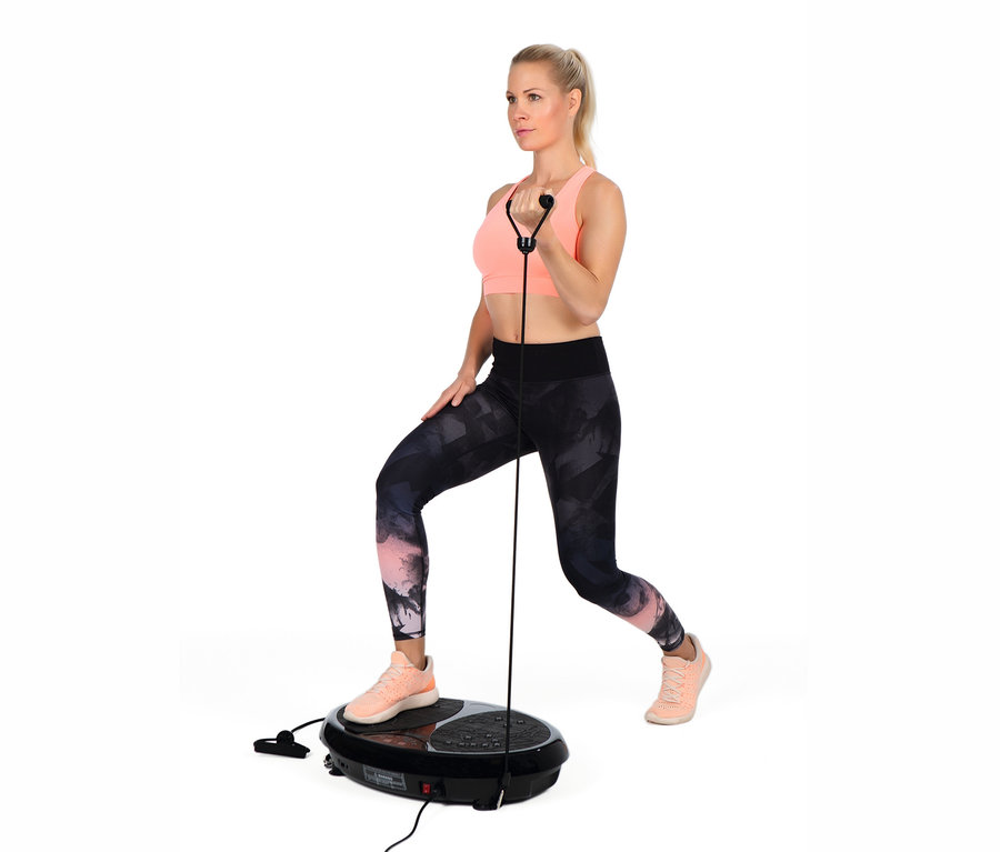 Blonde Frau trainiert mit VITALmaxx Vibrationstrainer, steht darauf und hält einen Griff.