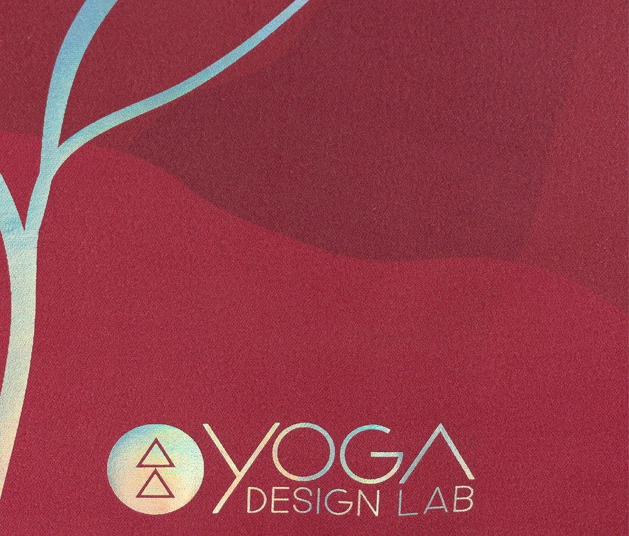 Detailaufnahme einer roten Yogamatte mit Yoga Design Lab Logo und blauem Muster.
