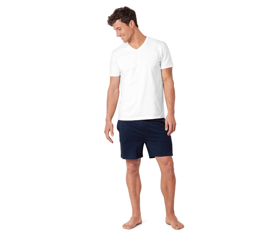 Mann trägt ein 4-teiliges Pyjama-Set, bestehend aus einem weißen T-Shirt und dunkelblauen Shorts.