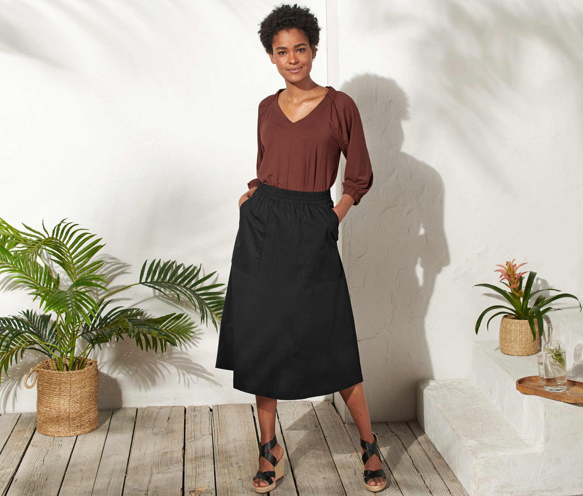 Frau posiert in einem schwarzen Popeline-Rock.