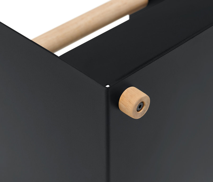 Detailaufnahme einer Ecke eines schwarzen Kaminholz-Korbs mit Holzgriff.