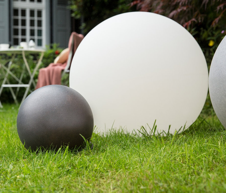 Drei 8 seasons design Solar-Leuchtkugeln stehen auf einer Wiese.