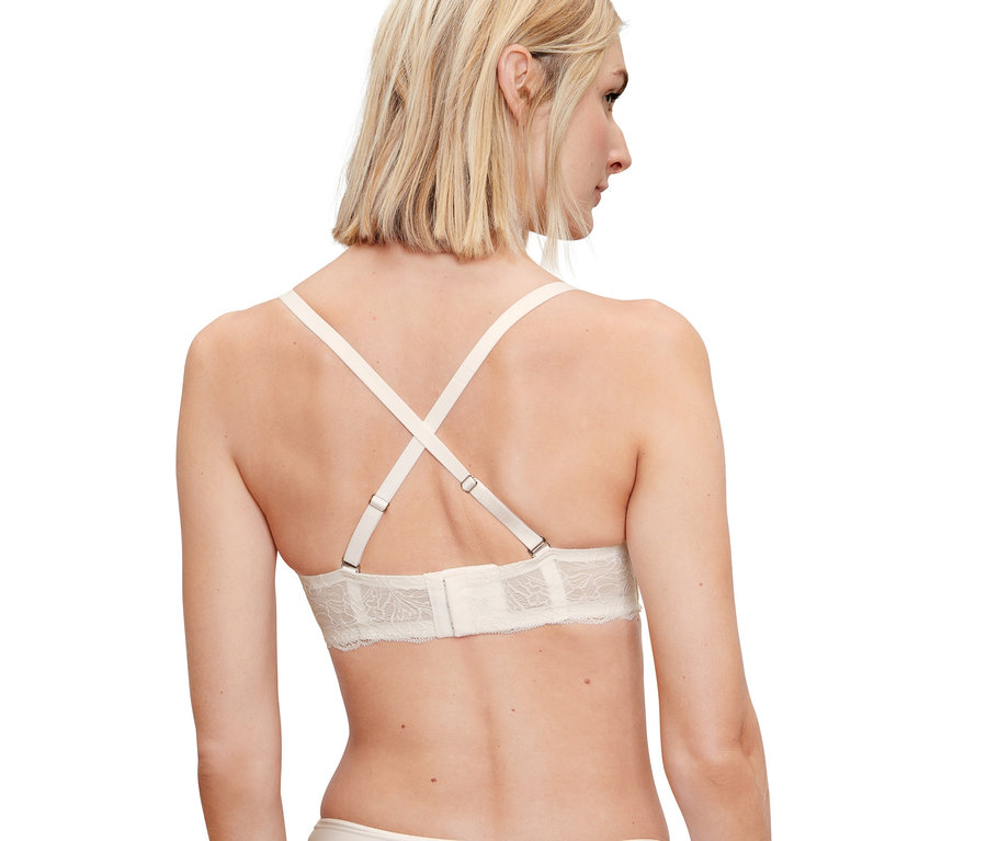 Rückansicht einer blonden Frau, die einen Multistyle-BH und nudefarbene Slips trägt.