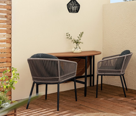 Außenterrasse mit 2-in-1-Sofa-Liege Elin, zwei Beistelltischen Elin, Dining-Sessel mit Textilgeflecht und Ausklapptisch Elin.