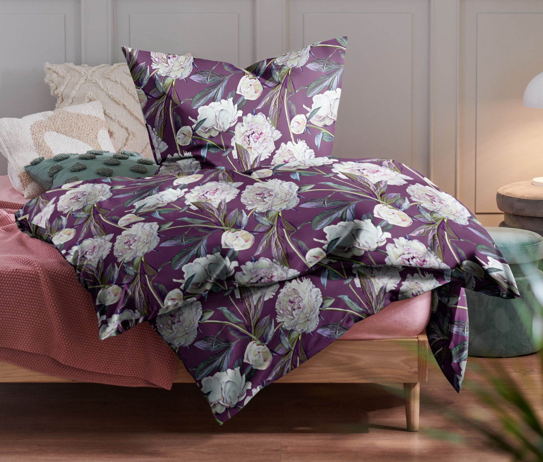 Auf dem Bett liegt lilafarbene Renforcé-Bettwäsche in verschiedenen Größen mit Blumenmuster.