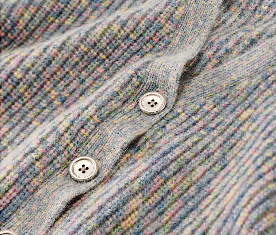 Detailansicht einer Kinder-Strickjacke mit Wolle und Knöpfen.