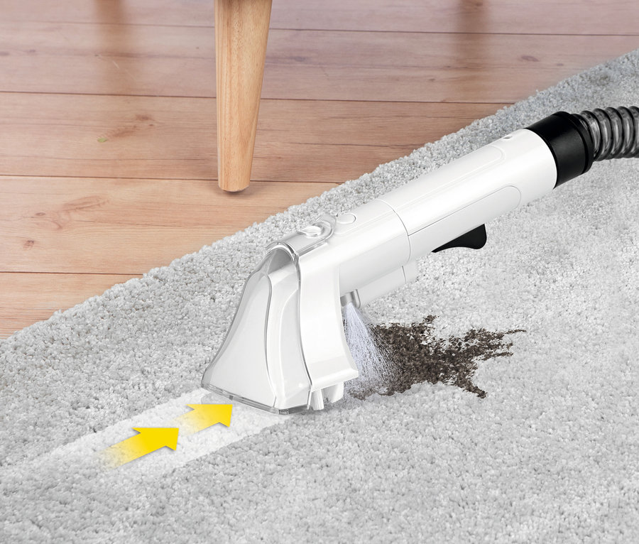 Düse des N8Werk Teppich-und-Polsterreinigers »3522« reinigt einen Fleck auf einem grauen Teppich.