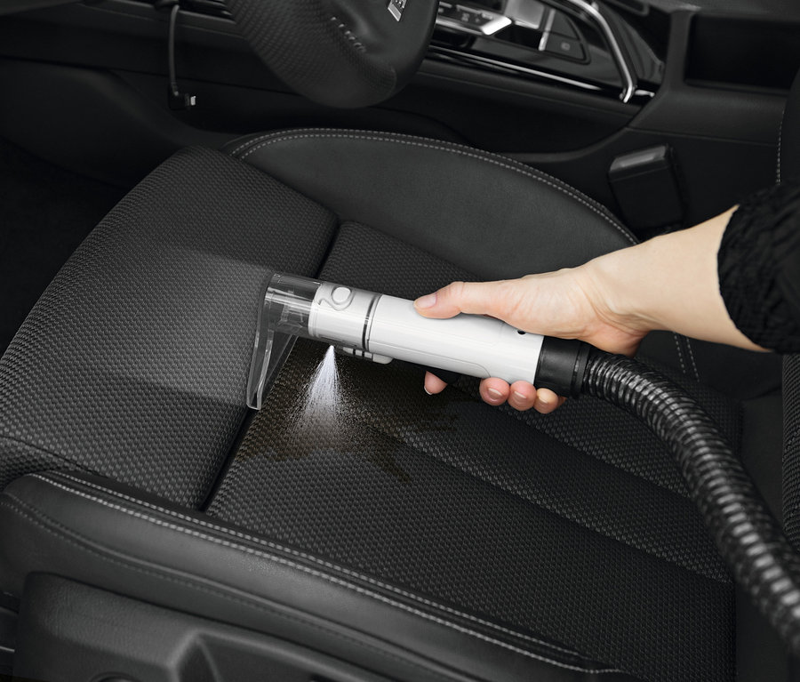Eine Hand reinigt einen Autositz mit dem N8Werk Teppich-und-Polsterreiniger »3522«.