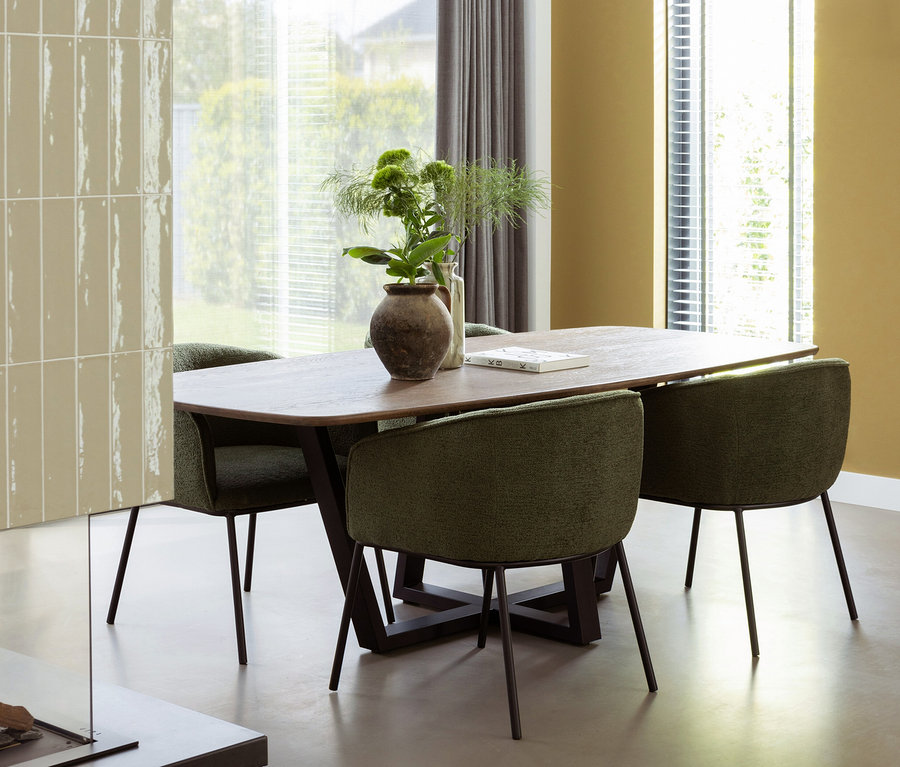 Esszimmer Interieur mit Holztisch und vier grünen Woood Leon Stühlen.