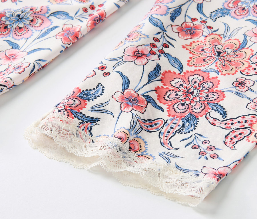 Detailansicht einer Pyjamahose mit Allover-Blumenmuster und Spitzenbesatz.