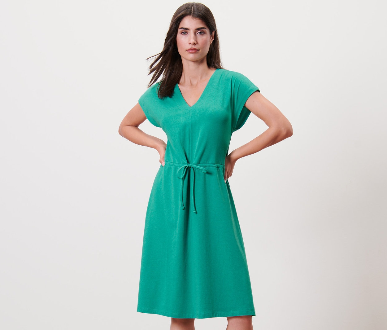 Frau posiert in Jerseykleid mit Bindeband.