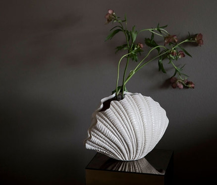 Blumen in der Vase »Shell« auf einem Tisch.