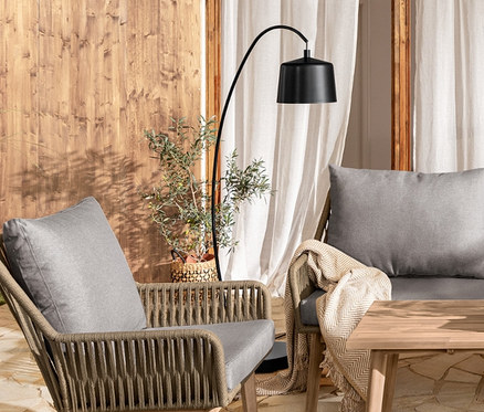 Outdoor-Szene mit Bogenleuchte aus Metall, Lounge-Dining-Set, großer Konsole mit 2 Ebenen »Lenja« und 2 Pflanzsäulen »Tinus«.