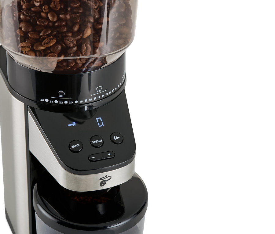 Detailaufnahme einer elektrischen Kaffeemühle mit Waage, oben Kaffeebohnen.