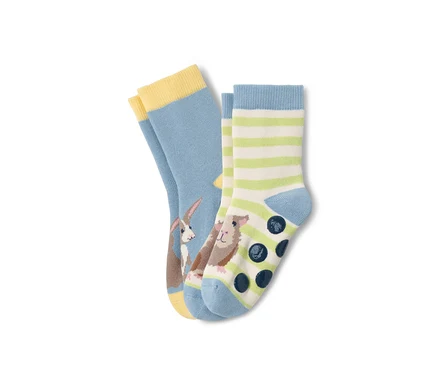 Zwei Paar Kleinkind-Antirutsch-Socken: ein Paar hellblau mit Kaninchen, das andere gestreift mit Meerschweinchen und Antirutschpunkten.