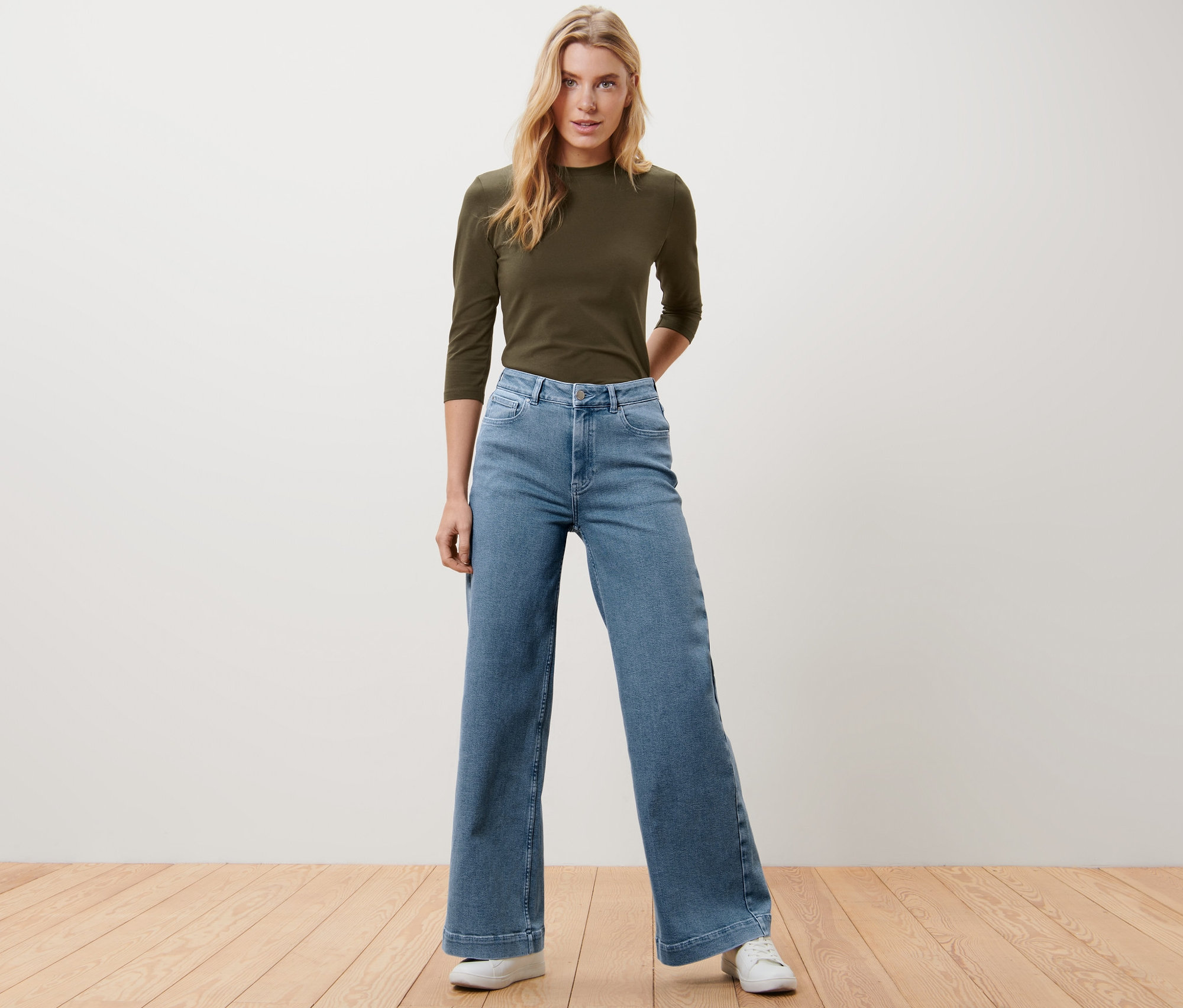 Blonde Frau posiert in Wide Leg Jeans – Fit »Viki« und olivgrünem Shirt.
