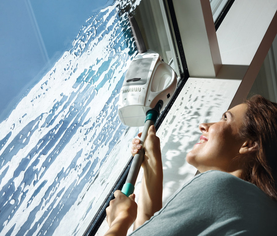 Frau verwendet Fenstersauger »DRY &amp; Clean Classic« auf einem Fenster.