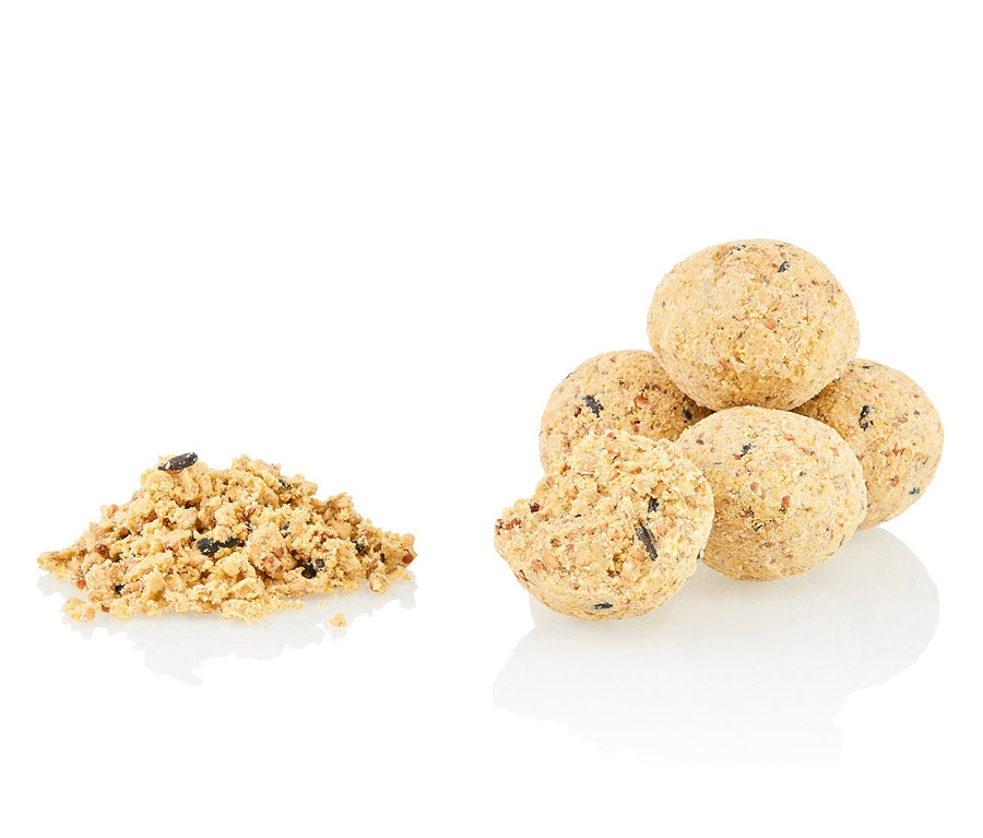 Ein Haufen zerbröselter Meisenknödel und ein Stapel aus fünf ganzen Meisenknödel.