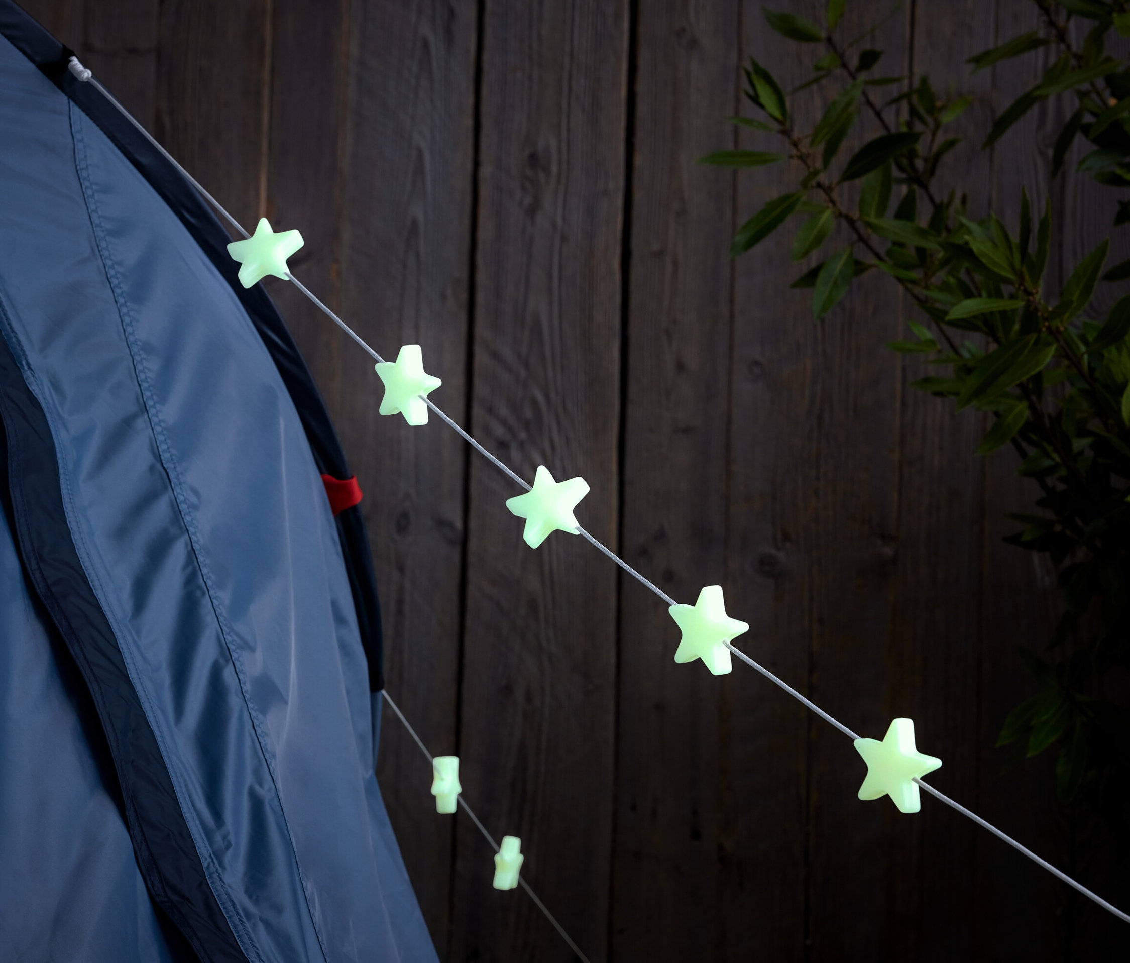 An einer Zeltleine hängen 8 nachtleuchtende Markierungsclips.