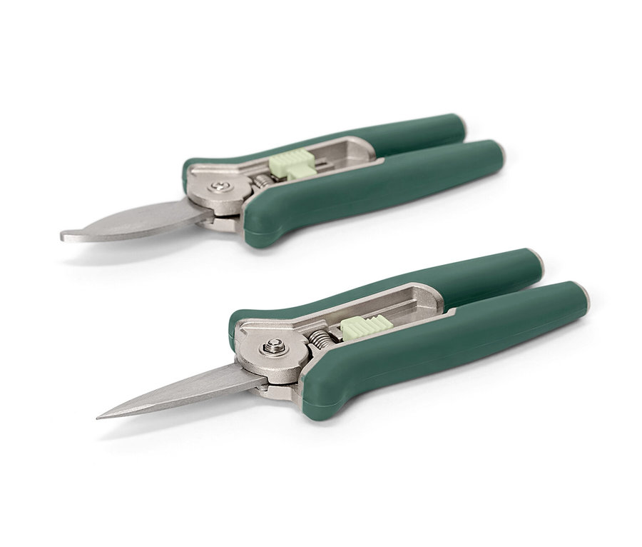 Zwei Mini-Pflegescheren liegen auf weißem Grund.