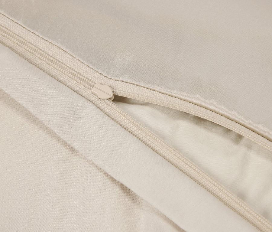 Detailaufnahme eines beigen Bettbezugs mit Reißverschluss.