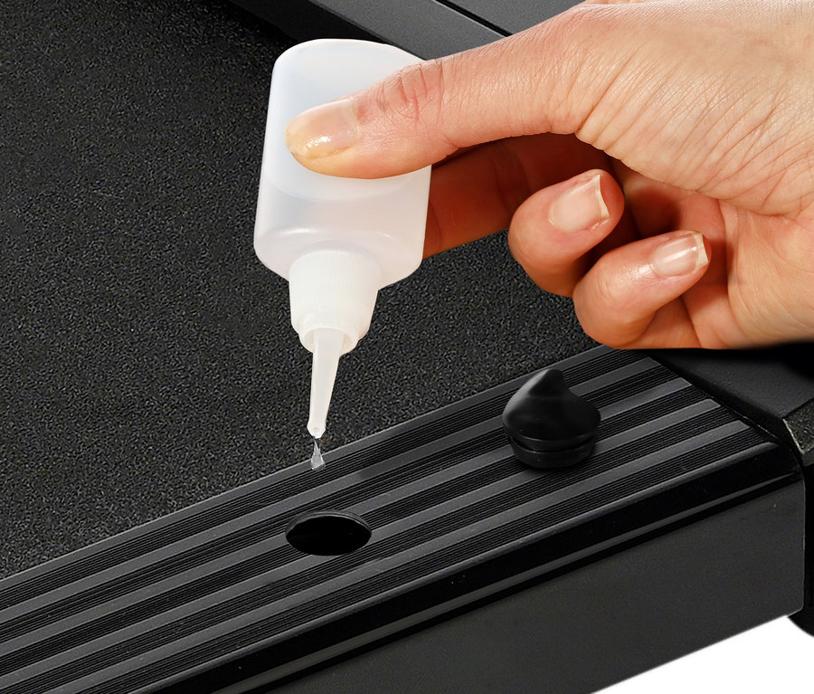 Eine Hand ölt ein Walking-Pad »4.1«.