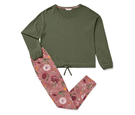 Ein grünes Langarmshirt und eine rosafarbene Hose mit Blumenmuster liegen auf einem weißen Hintergrund.