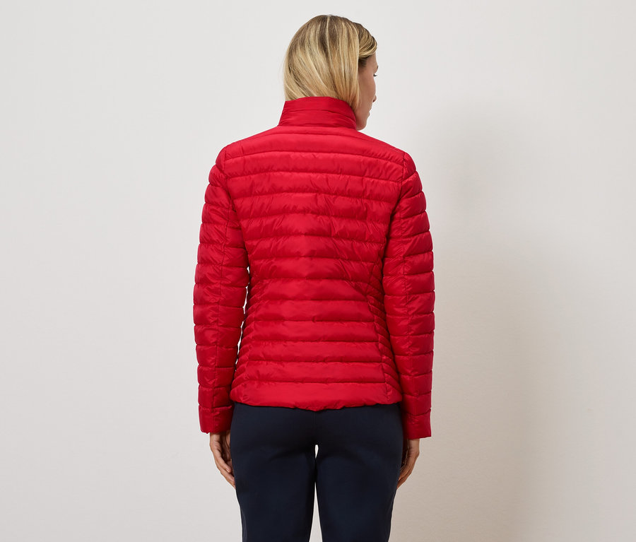 Frau mit roter Steppjacke, von hinten gesehen.