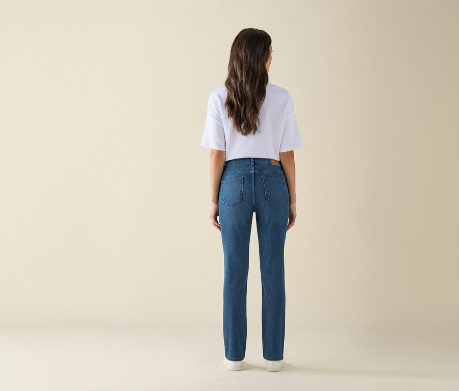 Rückansicht einer Frau in blauen Jeans und weißem T-Shirt.