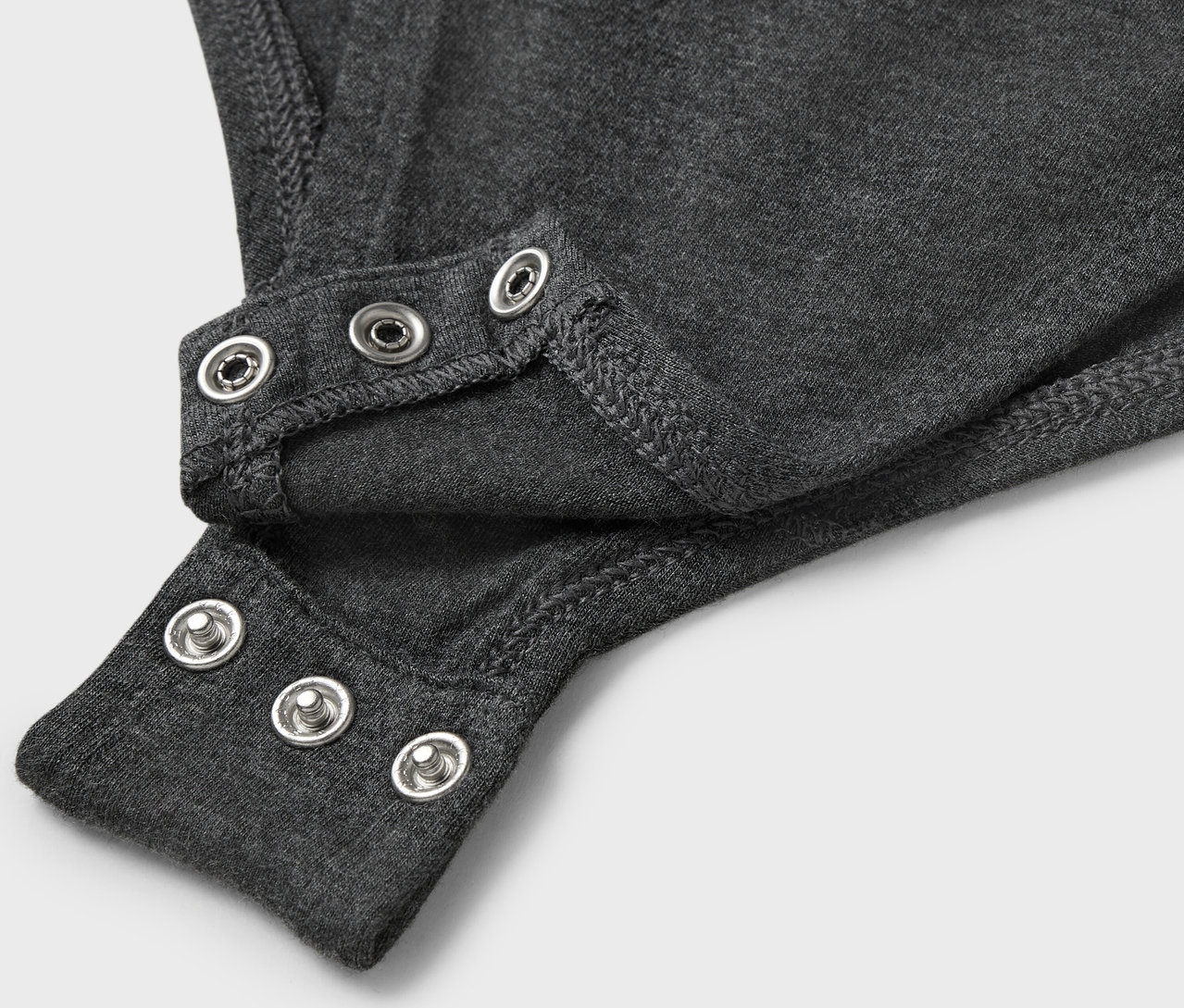 Detailaufnahme eines grauen Bodys mit Druckknöpfen.