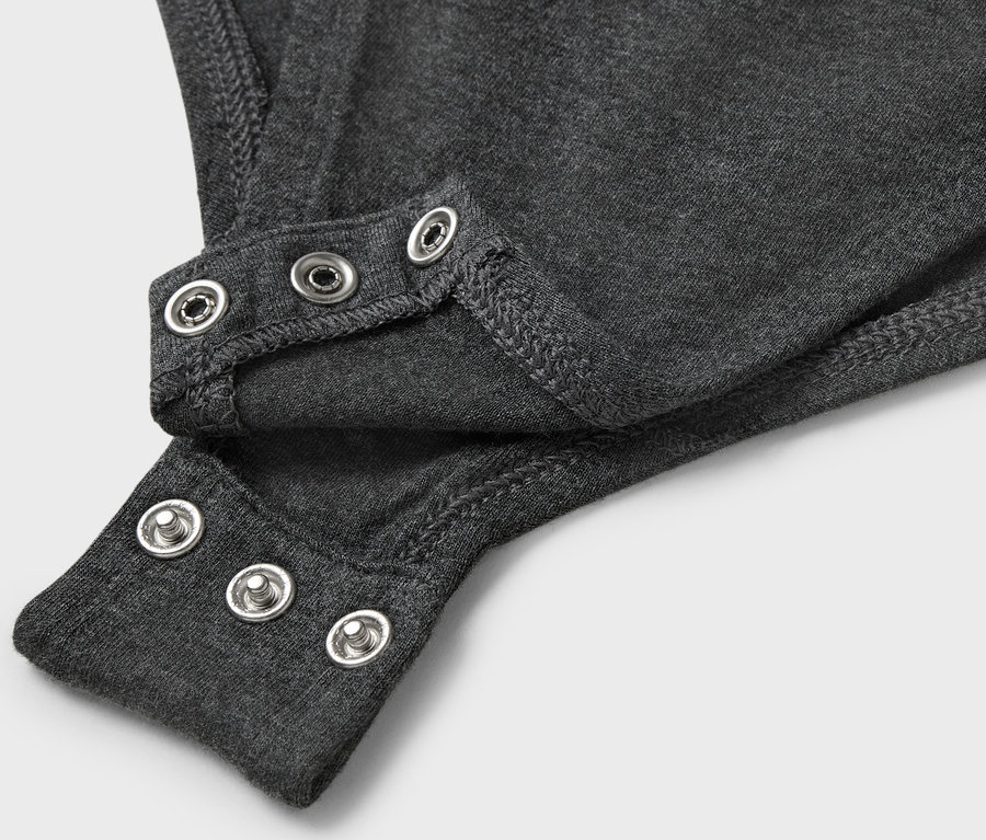 Detailaufnahme eines grauen Bodys mit Druckknöpfen.
