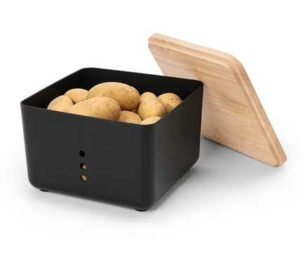 Eine schwarze Kartoffelbox ist mit Kartoffeln gefüllt, daneben liegt ein Holzdeckel.