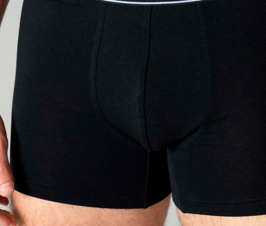 Nahaufnahme eines Mannes, der schwarze Boxershorts der Marke Tom Tailor trägt.